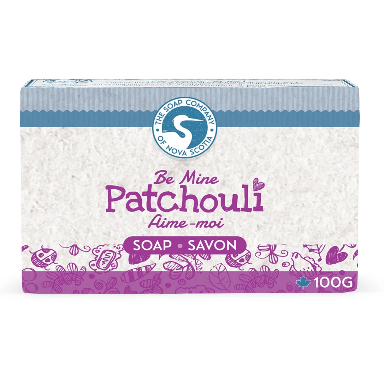 Three bars of soap with a jar of oil and patchouli flowers on a wooden surface